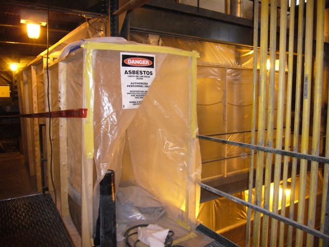 Warehouse/building sheeted with heavy plastic and tape for asbestos abatement with a Danger sign for safety