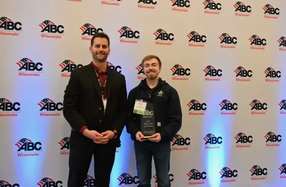 Two men and one is holding a safety award